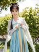 A woman in a blue and white hanfu dress posing for a picture.