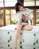 A woman sitting on top of a locker reading a book.