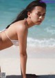 A woman in a white bikini on the beach.