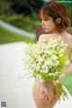 A naked woman holding a bunch of flowers.