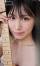 A young woman holding a guitar in her hands.