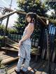 A woman standing on a wooden deck next to a bench.