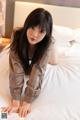 A woman laying on top of a white bed.