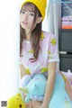 A young woman sitting on a bed with a stuffed animal.